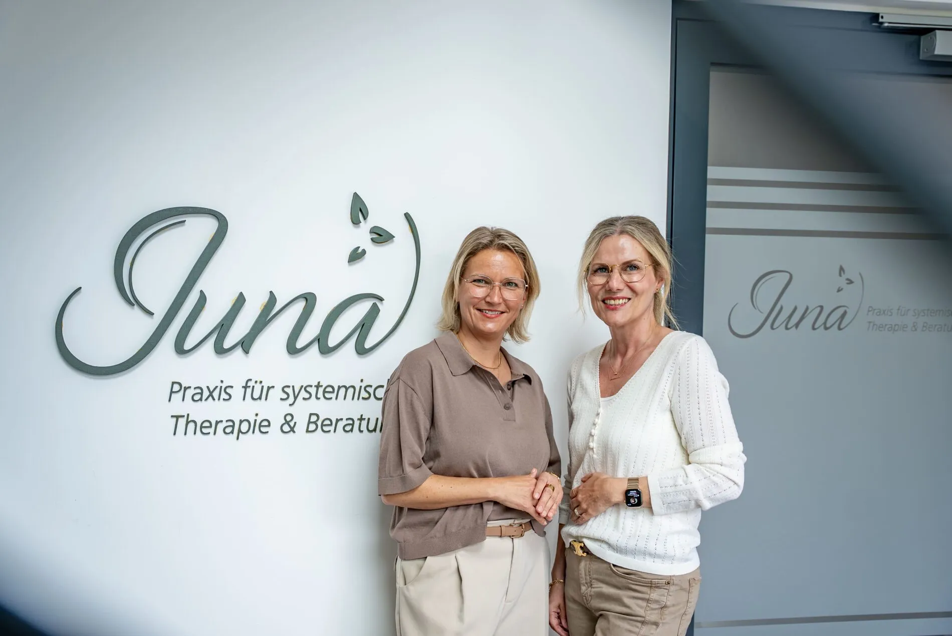 Die Gründerinnen der Praxis JUNA vor der Logowand in Herten