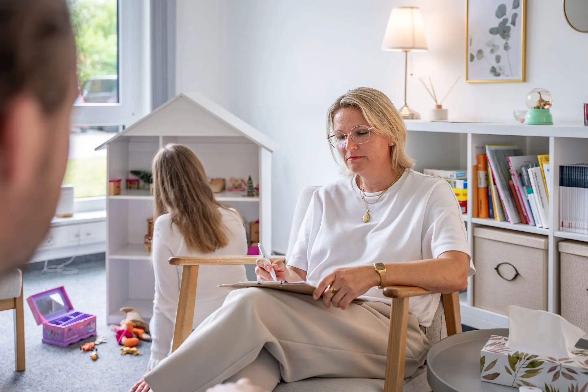 Systemische Fachkraft begleitet ein Kind im Spielbereich der Praxis JUNA